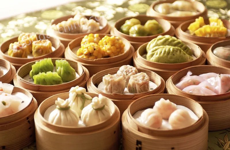 A variety of traditional Cantonese dim sum dishes including har gow, siu mai, and BBQ pork buns.